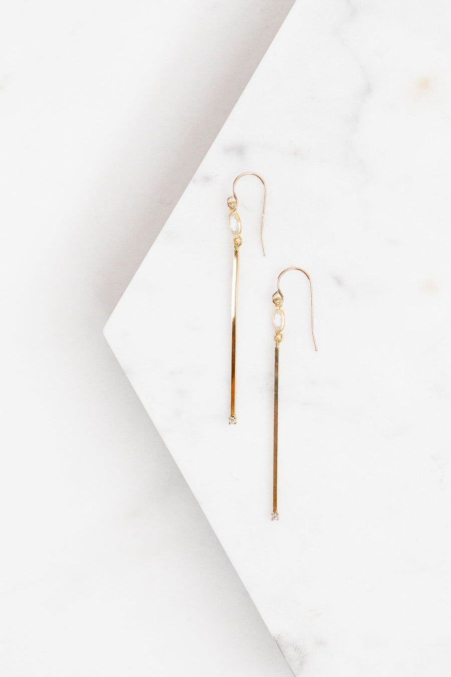 Find the perfect pair of earrings you're looking for from Charme Silkiner! These gold and CZ bezel drop earrings are stunning with their narrow bar and CZ accents. Perfect to dress or dress down any outfit the Vanna Earrings are the perfect must have for everyone!